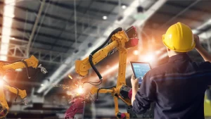 Safety in Manufacturing Site: Man looking at robots performing dangerous welding as it sparks.